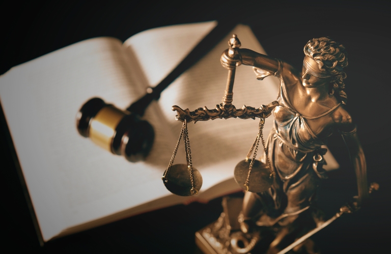 Lady Justice statue and books in background
